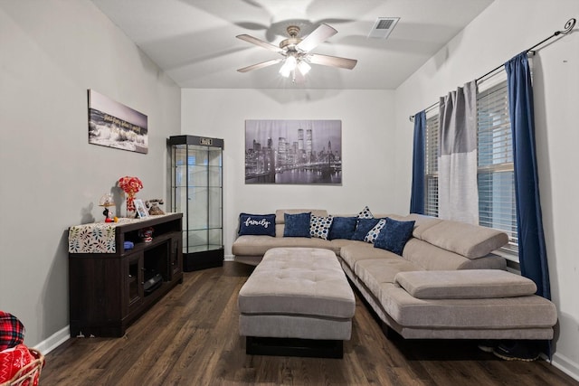 living room with dark wood-type flooring, visible vents, a ceiling fan, and baseboards
