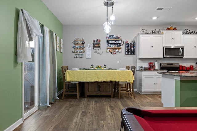 kitchen with white cabinets, visible vents, baseboards, appliances with stainless steel finishes, and dark wood-style flooring