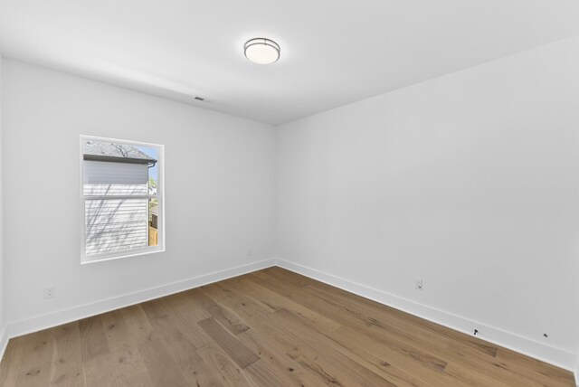 unfurnished room with wood finished floors and baseboards