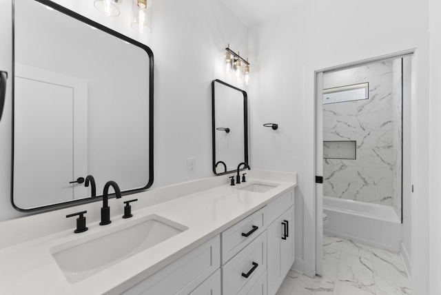 bathroom featuring double vanity, marble finish floor, toilet, and a sink