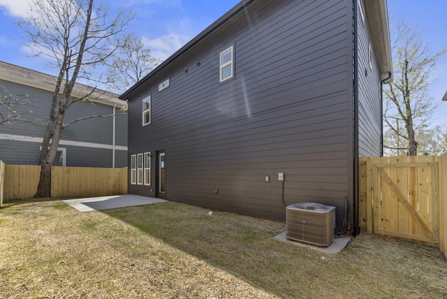back of house with a gate, central AC unit, a lawn, fence private yard, and a patio