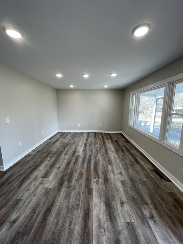 unfurnished room featuring dark wood finished floors, baseboards, and recessed lighting