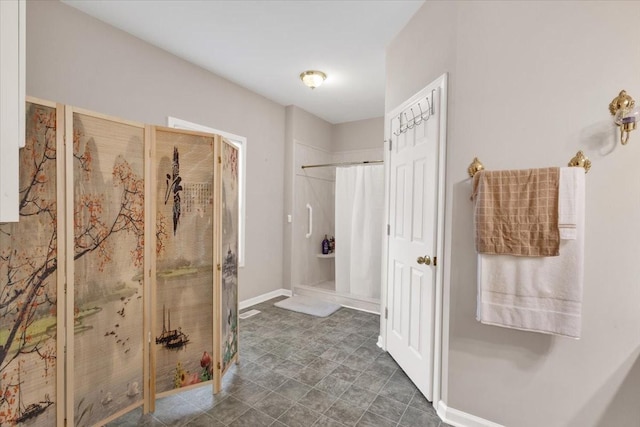 bathroom featuring a stall shower and baseboards