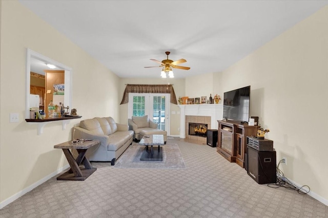 carpeted living room featuring a fireplace, a ceiling fan, and baseboards