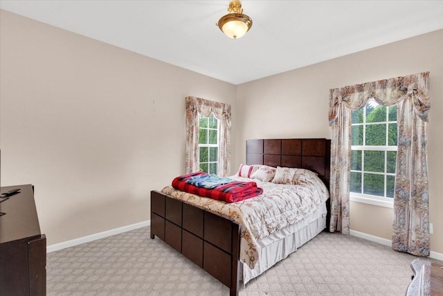 bedroom with multiple windows, carpet floors, and baseboards