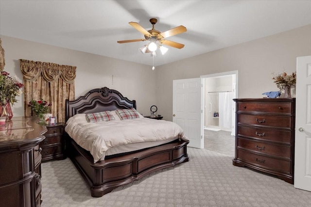 bedroom with ceiling fan, connected bathroom, and light colored carpet