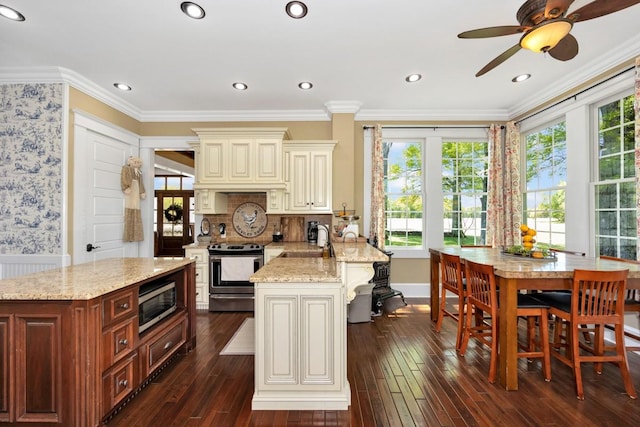 23475 Slate Rd, Athens, AL 35614 - kitchen featuring dark wood-style floors, cream cabinetry, a sink, light stone countertops, and appliances with stainless steel finishes