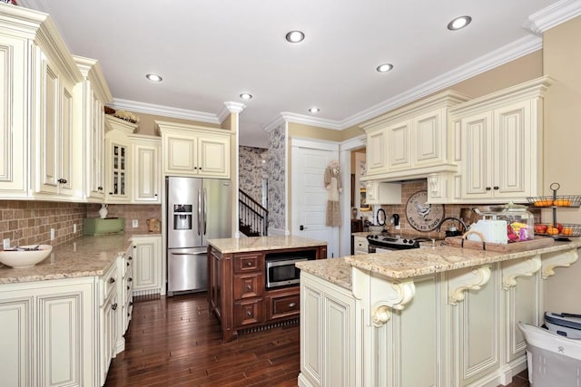 23475 Slate Rd, Athens, AL 35614 - kitchen featuring cream cabinetry, a peninsula, appliances with stainless steel finishes, and light stone countertops