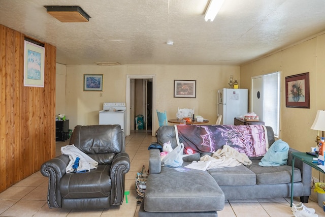 living area with washer / clothes dryer, a textured ceiling, and light tile patterned floors
