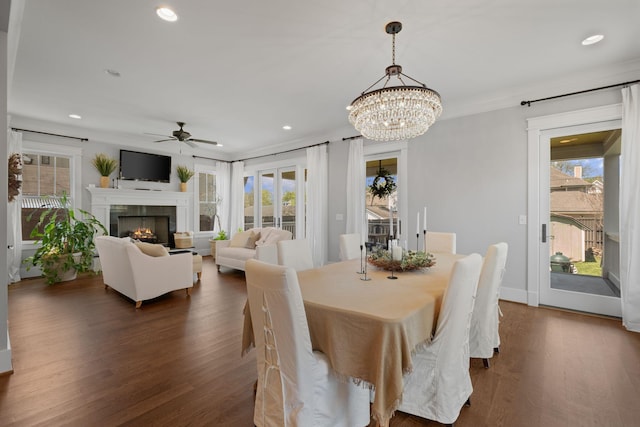 4306 Idaho Ave, Nashville, TN 37209 - dining space with dark wood-type flooring, a tiled fireplace, a healthy amount of sunlight, and ceiling fan with notable chandelier