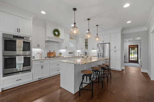 4306 Idaho Ave, Nashville, TN 37209 - kitchen featuring white cabinets, backsplash, appliances with stainless steel finishes, and a breakfast bar area