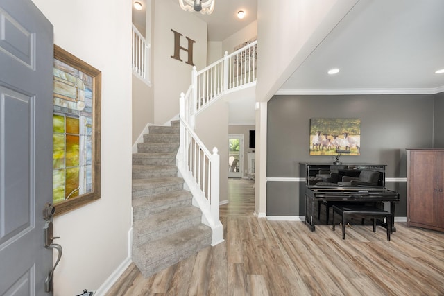 entryway featuring stairway, wood finished floors, baseboards, and crown molding