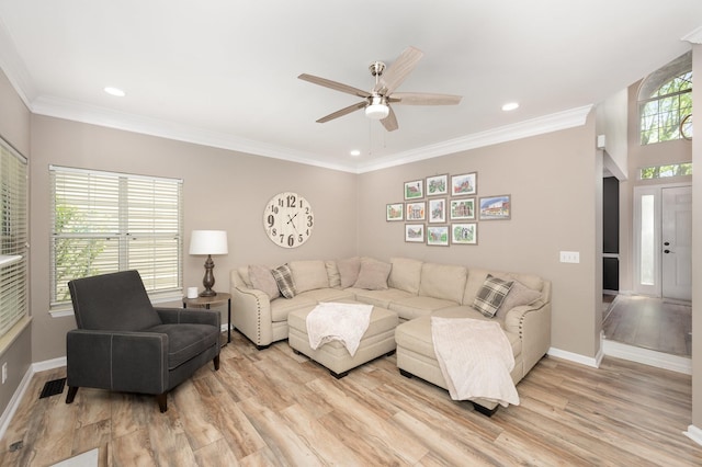 living room featuring a ceiling fan, light wood-style floors, baseboards, recessed lighting, and crown molding