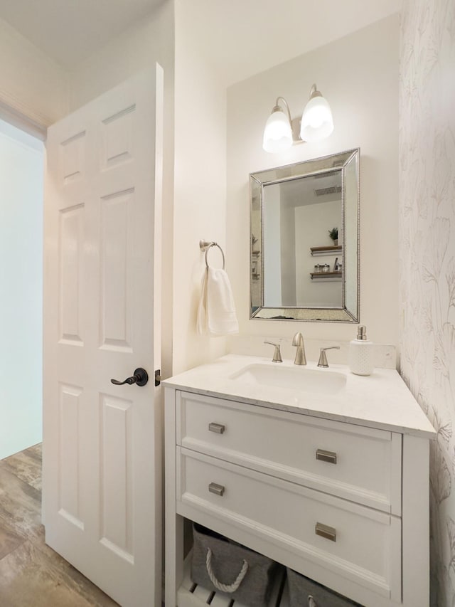 bathroom featuring wallpapered walls, vanity, and wood finished floors