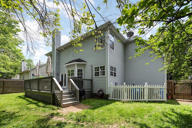 rear view of property with a wooden deck, a gate, and a chimney