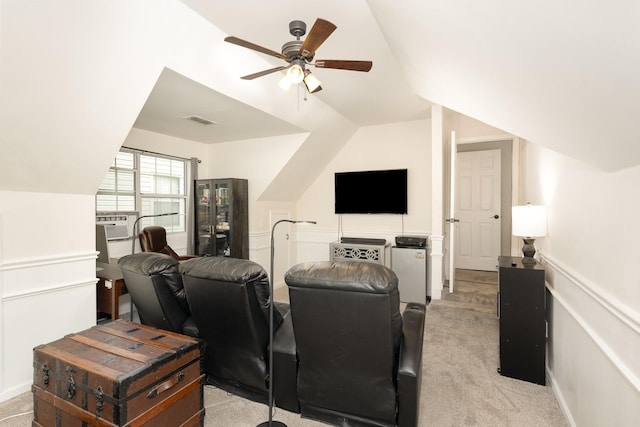 living area with vaulted ceiling, ceiling fan, and light carpet
