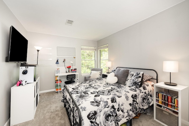 bedroom featuring light carpet and baseboards