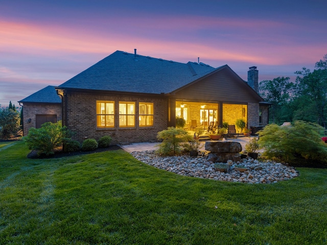 1320 Ashby Valley Ln, Arrington, TN 37014 - rear view of house featuring a chimney, a patio area, roof with shingles, a yard, and brick siding