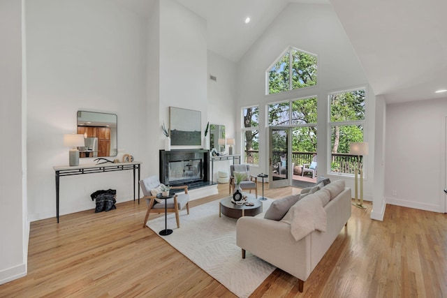 635 Harpeth Trace Dr, Nashville, TN 37221 - living room featuring a glass covered fireplace, baseboards, high vaulted ceiling, recessed lighting, and light wood-style flooring