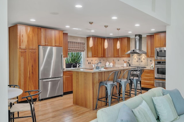 635 Harpeth Trace Dr, Nashville, TN 37221 - kitchen with wall chimney exhaust hood, appliances with stainless steel finishes, brown cabinets, and a kitchen bar