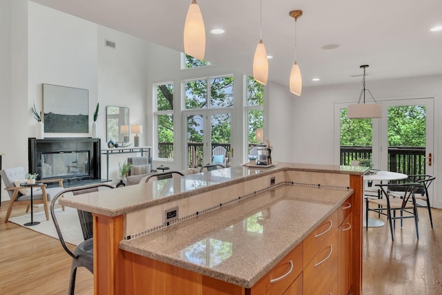 635 Harpeth Trace Dr, Nashville, TN 37221 - kitchen with visible vents, brown cabinetry, light wood-style flooring, and a center island with sink