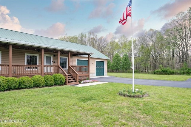 547 Clear Creek Ln, Monterey, TN 38574 - view of front of home featuring aphalt driveway, an attached garage, a porch, a front yard, and metal roof