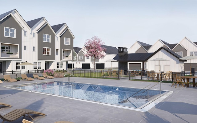 community pool featuring fence, a patio area, and a residential view