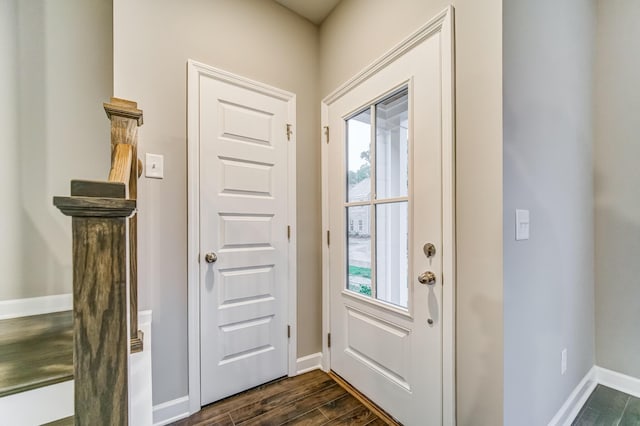 doorway featuring baseboards and dark wood-style floors