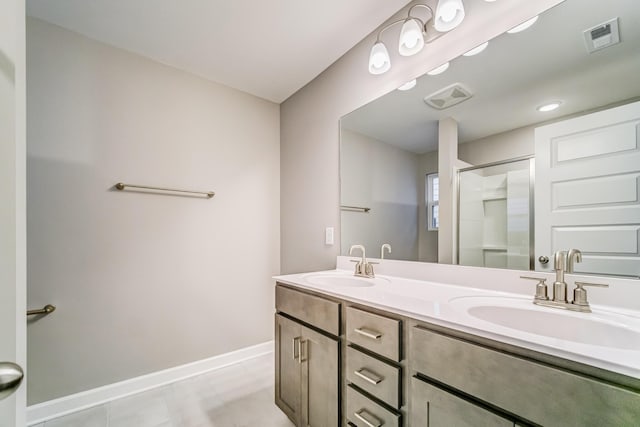 bathroom with baseboards, a sink, visible vents, and a stall shower
