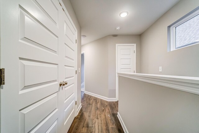 hallway featuring baseboards and dark wood-type flooring