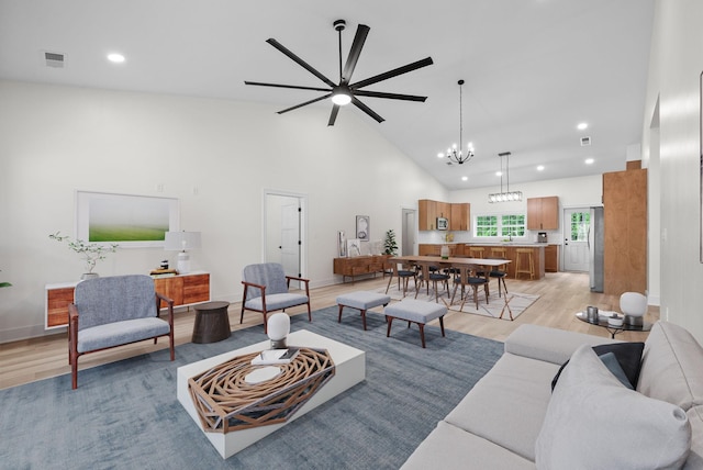 4151 Southside Rd, Southside, TN 37171 - living room with visible vents, light wood-style floors, high vaulted ceiling, recessed lighting, and ceiling fan with notable chandelier