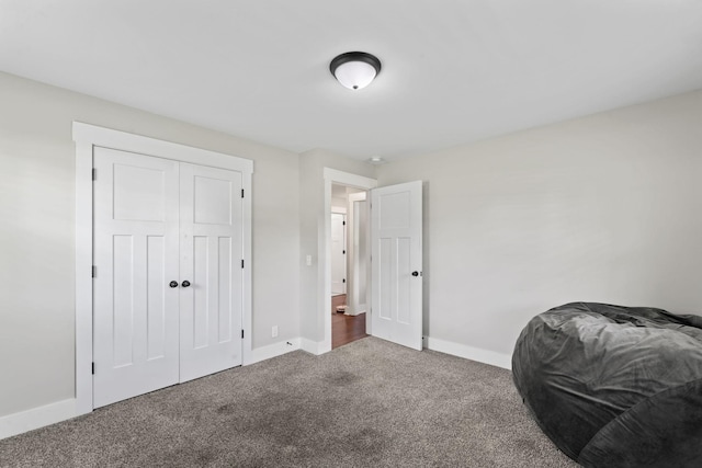 carpeted bedroom with baseboards and a closet