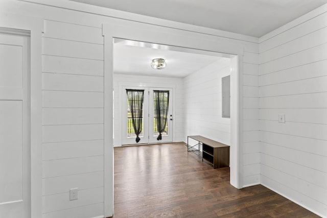 interior space featuring wooden walls, electric panel, french doors, and dark wood-type flooring
