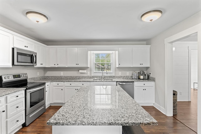 kitchen featuring white cabinets, appliances with stainless steel finishes, dark wood-style floors, and a sink