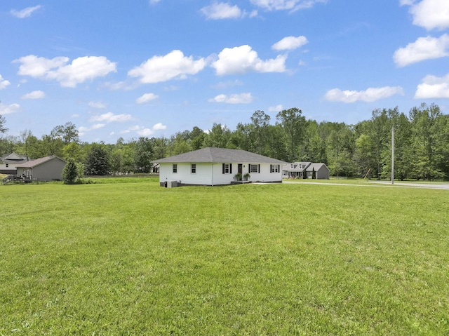 back of house featuring a yard and a wooded view