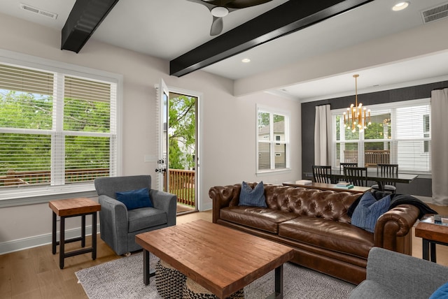 living room featuring beamed ceiling, visible vents, a wealth of natural light, and light wood-style floors