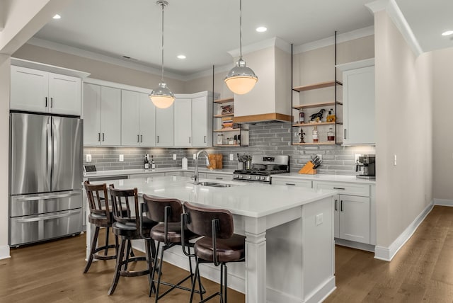 kitchen with open shelves, wood finished floors, a sink, light countertops, and appliances with stainless steel finishes
