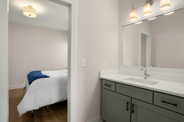 bathroom featuring wood finished floors, baseboards, connected bathroom, and vanity