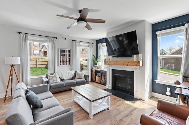 7025 Bennett Dr, Mount Juliet, TN 37122 - living room featuring a fireplace with flush hearth, baseboards, light wood finished floors, and plenty of natural light