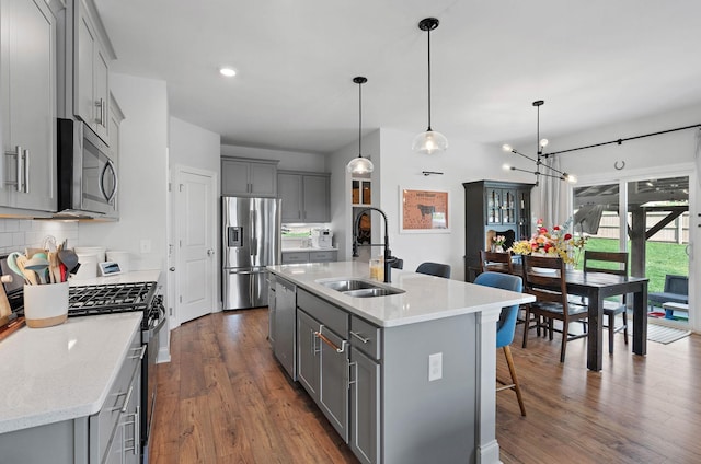 7025 Bennett Dr, Mount Juliet, TN 37122 - kitchen featuring a kitchen breakfast bar, stainless steel appliances, a sink, gray cabinetry, and dark wood-style flooring