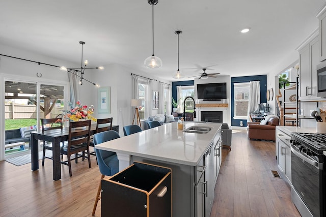 7025 Bennett Dr, Mount Juliet, TN 37122 - kitchen featuring a sink, a center island with sink, open floor plan, ceiling fan with notable chandelier, and appliances with stainless steel finishes