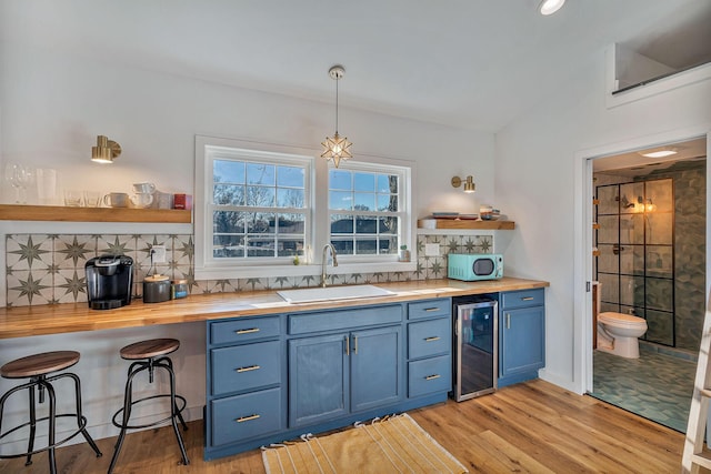 474 Sunliner Dr, Nashville, TN 37209 - kitchen featuring open shelves, butcher block countertops, beverage cooler, a sink, and blue cabinetry