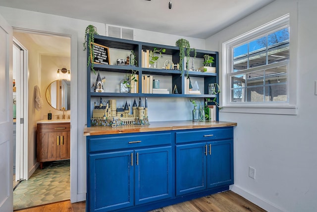 474 Sunliner Dr, Nashville, TN 37209 - bar with visible vents, baseboards, light wood-style floors, a bar, and a sink