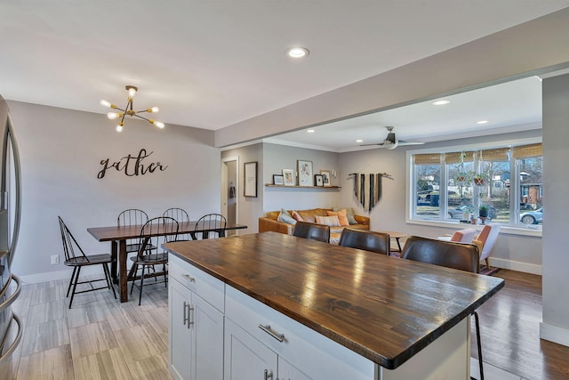 474 Sunliner Dr, Nashville, TN 37209 - kitchen with a breakfast bar, baseboards, recessed lighting, white cabinets, and wood counters