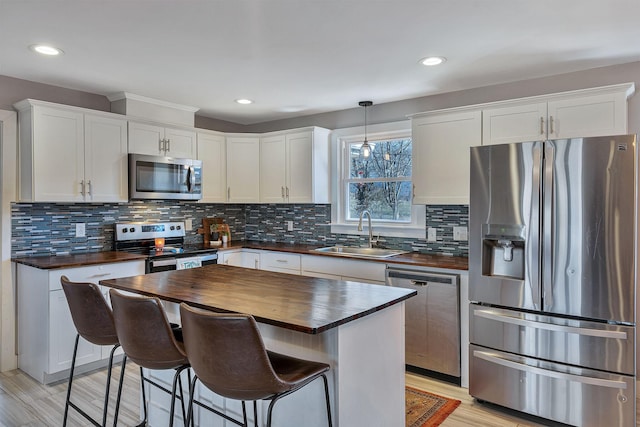 474 Sunliner Dr, Nashville, TN 37209 - kitchen with a sink, wooden counters, stainless steel appliances, white cabinetry, and decorative backsplash