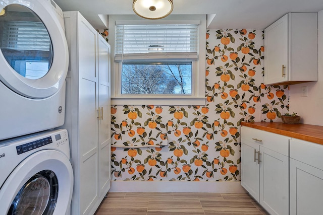 474 Sunliner Dr, Nashville, TN 37209 - laundry room with cabinet space, wallpapered walls, and stacked washing maching and dryer