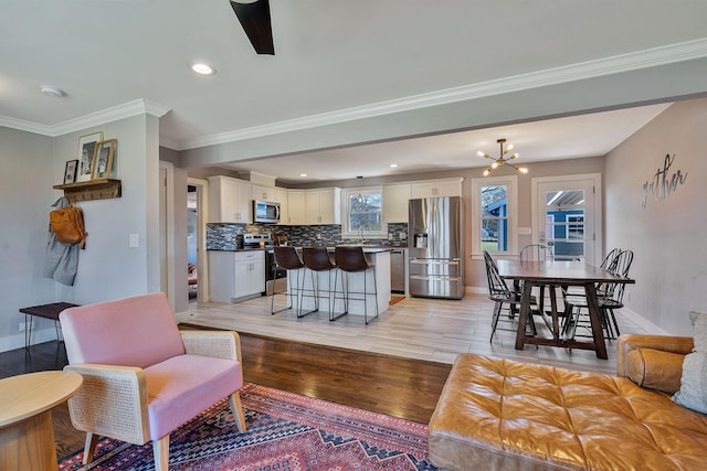 474 Sunliner Dr, Nashville, TN 37209 - living room with an inviting chandelier, recessed lighting, baseboards, light wood-type flooring, and ornamental molding