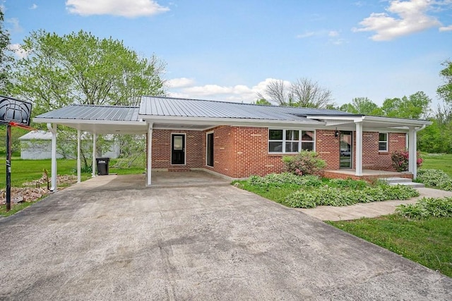 ranch-style house with driveway, a porch, brick siding, a carport, and metal roof