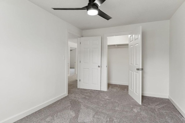 unfurnished bedroom with a closet, baseboards, a ceiling fan, and carpet