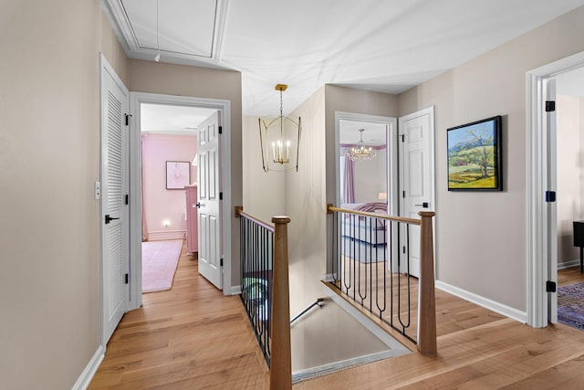 2931 Longford Dr, Murfreesboro, TN 37129 - hallway featuring an upstairs landing, light wood-style floors, baseboards, attic access, and a notable chandelier